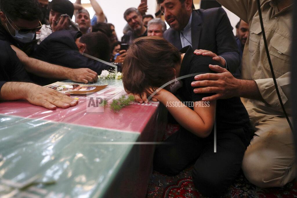 Vahid Salemi Son of Iran's Revolutionary Guard Col. Hassan Sayyad Khodaei mourns over his flag draped coffin during his funeral ceremony in Tehran, Iran, Tuesday, May 24, 2022. Iran's hard-line President Ebrahim Raisi vowed revenge on Monday over the killing of Sayyad Khodaei who was shot at his car by two assailants outside his home in Tehran, a still-mysterious attack on the country's powerful paramilitary force. (AP Photo/Vahid Salemi)