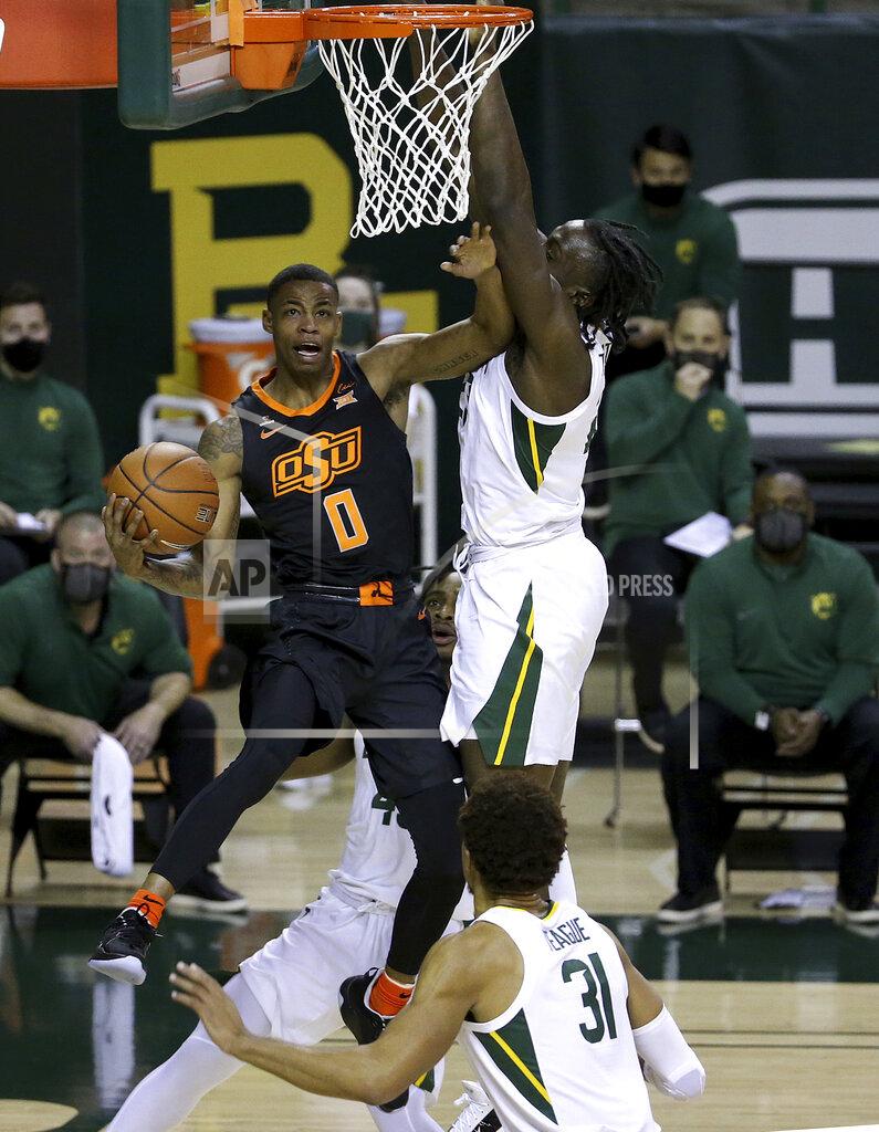 Jerry Larson Oklahoma State guard Avery Anderson III (0) attempts a shot past Baylor forward Jonathan Tchamwa Tchatchoua (23) in the first half of an NCAA college basketball game, Thursday, March 4, 2021, in Waco, Texas. (AP Photo/Jerry Larson)