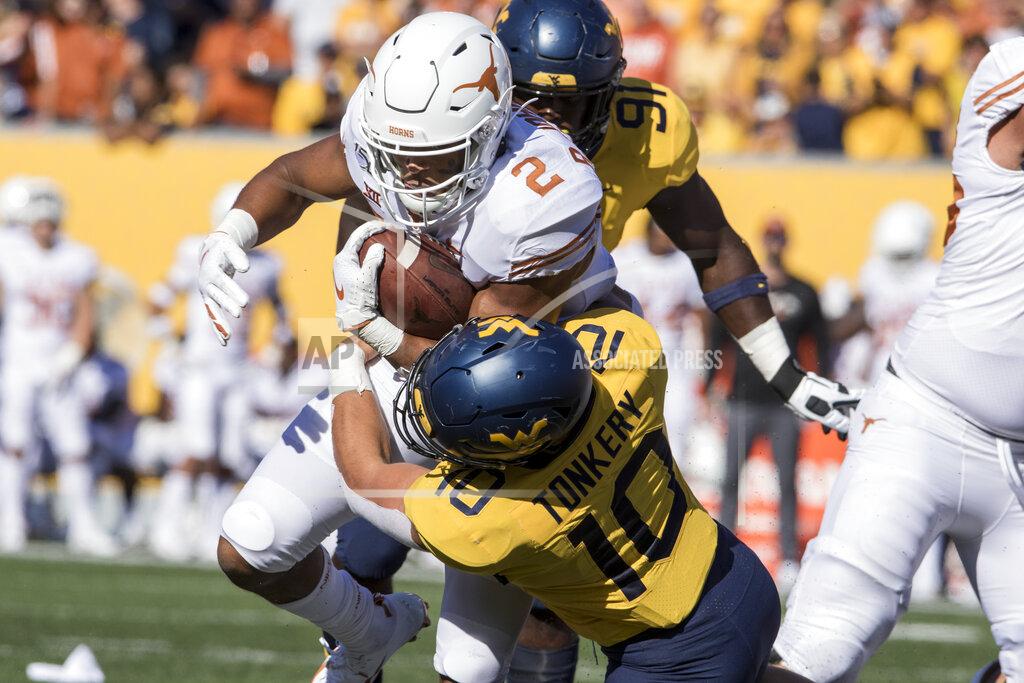 Ray Thompson Texas running back Roschon Johnson (2) is tackled by West Virginia linebacker Dylan Tonkery (10) during the first half of an NCAA college football game Saturday, Oct. 5, 2019, in Morgantown, W.Va. (AP Photo/Raymond Thompson)
