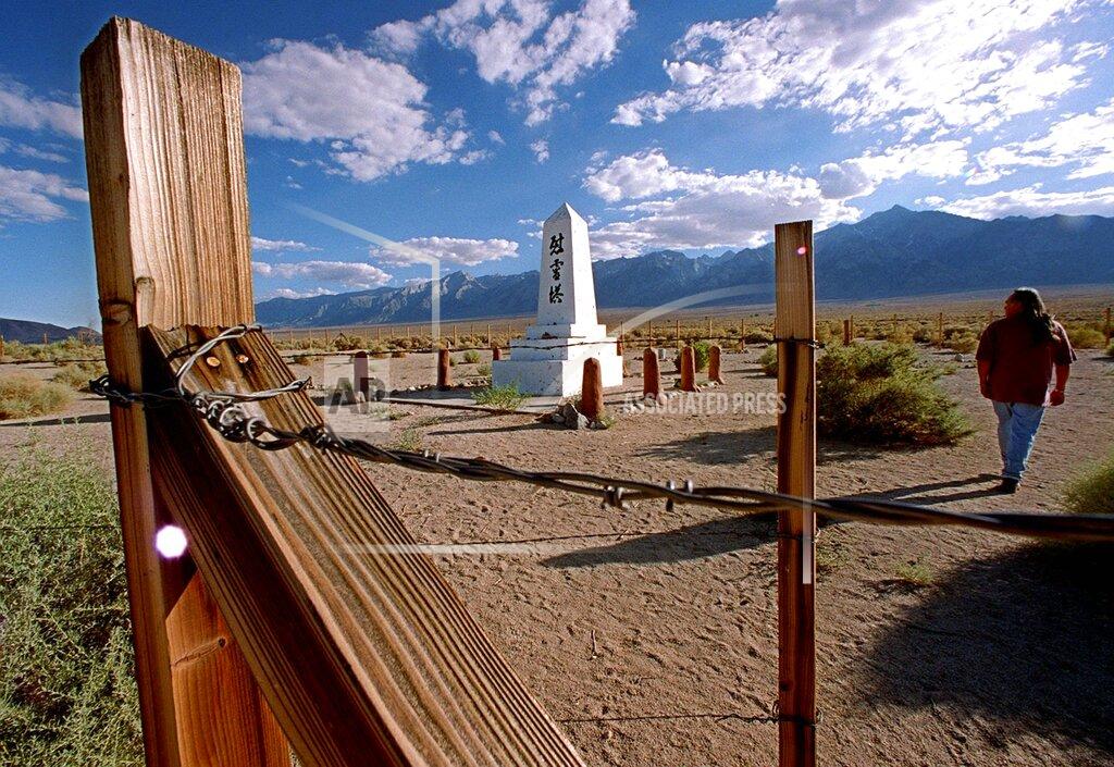 Damian Dovarganes FILE - A man walks through a cemetery on the site of the Manzanar Japanese internment camp near Independence, Calif., on July 24, 1997. The World War II internment camp is featured in a collection of mini-essays by American writers published online by the Frommer's guidebook company about places they believe helped shape and define America. (AP Photo/Damian Dovarganes, File)