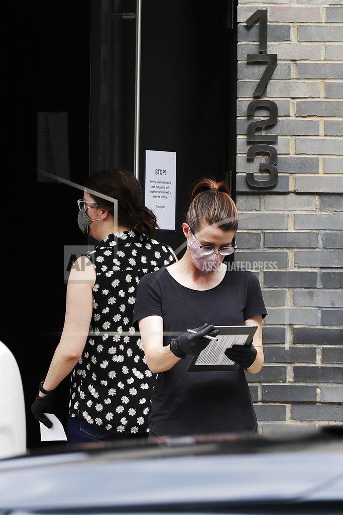 Nam Y. Huh Alinea restaurant staffer Michaela Kelly, right, checks carryout orders outside of the restaurant in Chicago, Saturday, June 20, 2020. Due to the coronavirus Alinea shifted to carryout on March 17. Since then, it has served 82,000 meals, said Nick Kokonas, the restaurant's co-owner. (AP Photo/Nam Y. Huh)