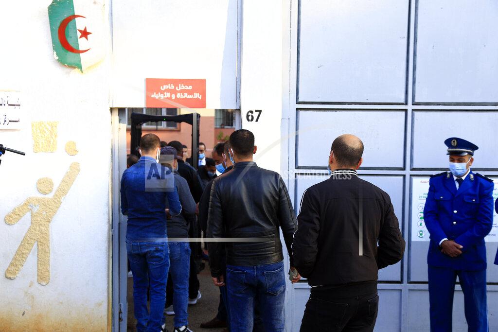 Toukik Doudou People wait in line outside a polling station prior to cast their ballot during a vote for a revised constitution, in Algiers, Sunday, Nov. 1, 2020. Algerians are voting on whether to approve a revised constitution that imposes term limits and aims at answering demands from pro-democracy protesters who pushed out the president last year. (AP Photo/Toufik Doudou)