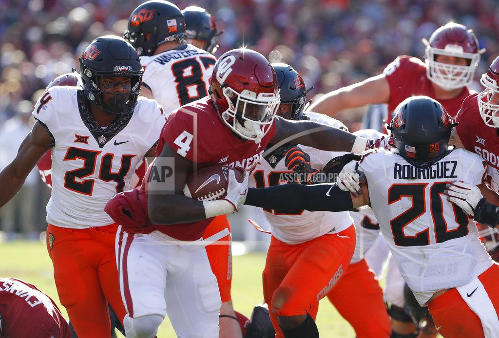 Alonzo Adams Oklahoma running back Trey Sermon (4) escapes a tackle by Oklahoma State safety Jarrick Bernard (24) and safety Malcolm Rodriguez (20) in the first half of an NCAA college football game in Norman, Okla., Saturday, Nov. 10, 2018. (AP Photo/Alonzo Adams)