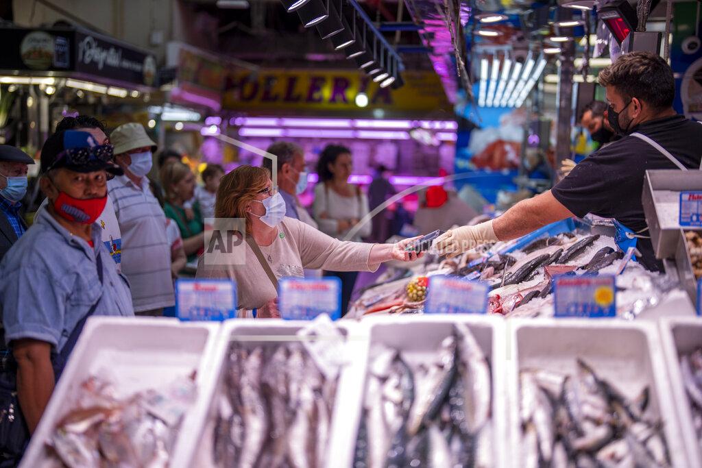 Manu Fernandez A customer pays for fish at the Maravillas market in Madrid, Thursday, May 12, 2022. Russia's war in Ukraine has accelerated inflation across Europe, with prices for energy, materials and food surging at rates not seen for decades. Inflation is expected to hit nearly 7% this year in the 27-nation EU and is contributing to slowing growth forecasts. (AP Photo/Manu Fernandez)