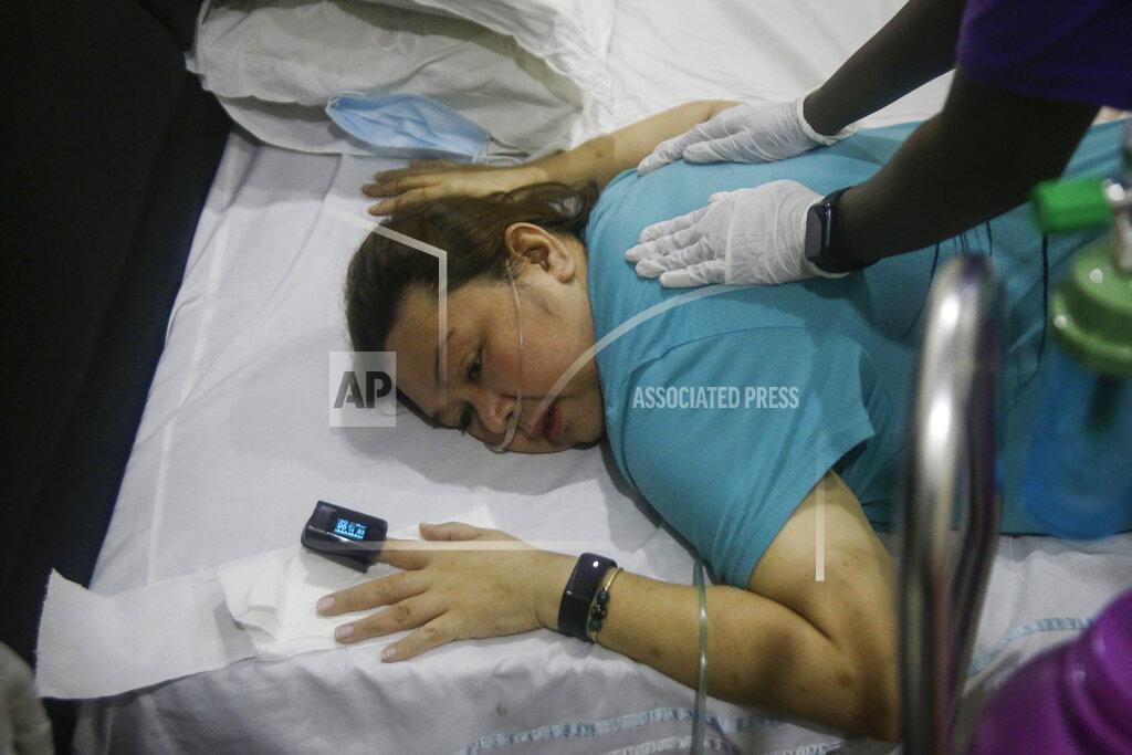 Sunday Alamba Maricar Tajo, 46, who is from the Philippines but moved to Nigeria in 2007 for work, receives oxygen from a private medical service at her house as she recovers from COVID-19 in Lagos, Nigeria Saturday, Feb. 6, 2021. She was resuscitated after falling unconscious in a hospital intensive care unit when her oxygen saturation levels dropped. (AP Photo/Sunday Alamba)