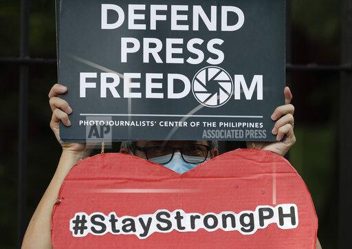 FILE - An employee of the country's largest TV network ABS-CBN, holds a slogan during a rally outside the House of Representatives in Manila, Philippines, Thursday, July 9, 2020. A gunman shot and killed a journalist Wednesday night Dec. 8, 2021, who was watching TV at a store in a central Philippine city, in a brazen attack in what has long been regarded as one of the world's most dangerous countries for journalists. (AP Photo/Aaron Favila, File)