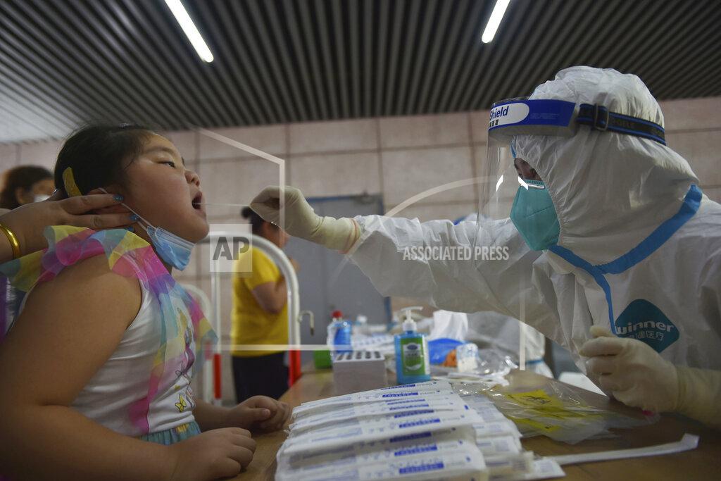 Uncredited A nurse takes throat swab samples in new round of COVID-19 testing in Nanjing city in eastern China's Jiangsu province Monday, Aug. 2, 2021. The current coronavirus outbreaks in China, while still in the hundreds of cases in total, have spread much more widely than previous ones, reaching multiple provinces and cities including the capital, Beijing. Many of the cases have been identified as the highly contagious delta variant that is driving a resurgence in many countries. (Chinatopix via AP)