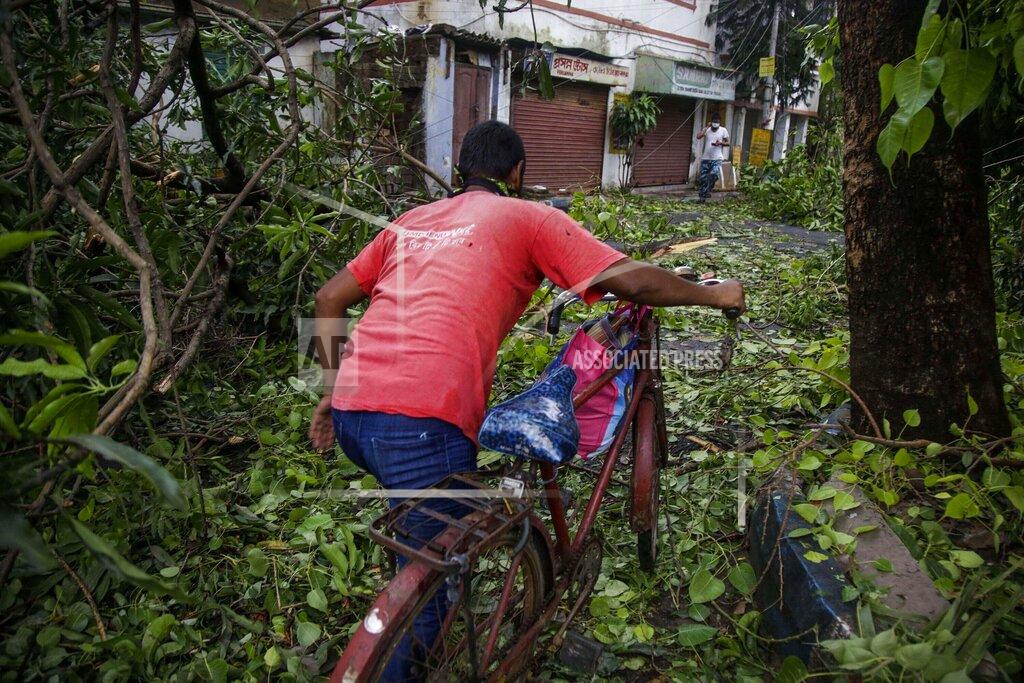 Bikas Das A man pushes his cycle past branches fallen after Cyclone Amphan hit the region in Kolkata, India, Thursday, May 21, 2020. A powerful cyclone ripped through densely populated coastal India and Bangladesh, blowing off roofs and whipping up waves that swallowed embankments and bridges and left entire villages without access to fresh water, electricity and communications. (AP Photo/Bikas Das)