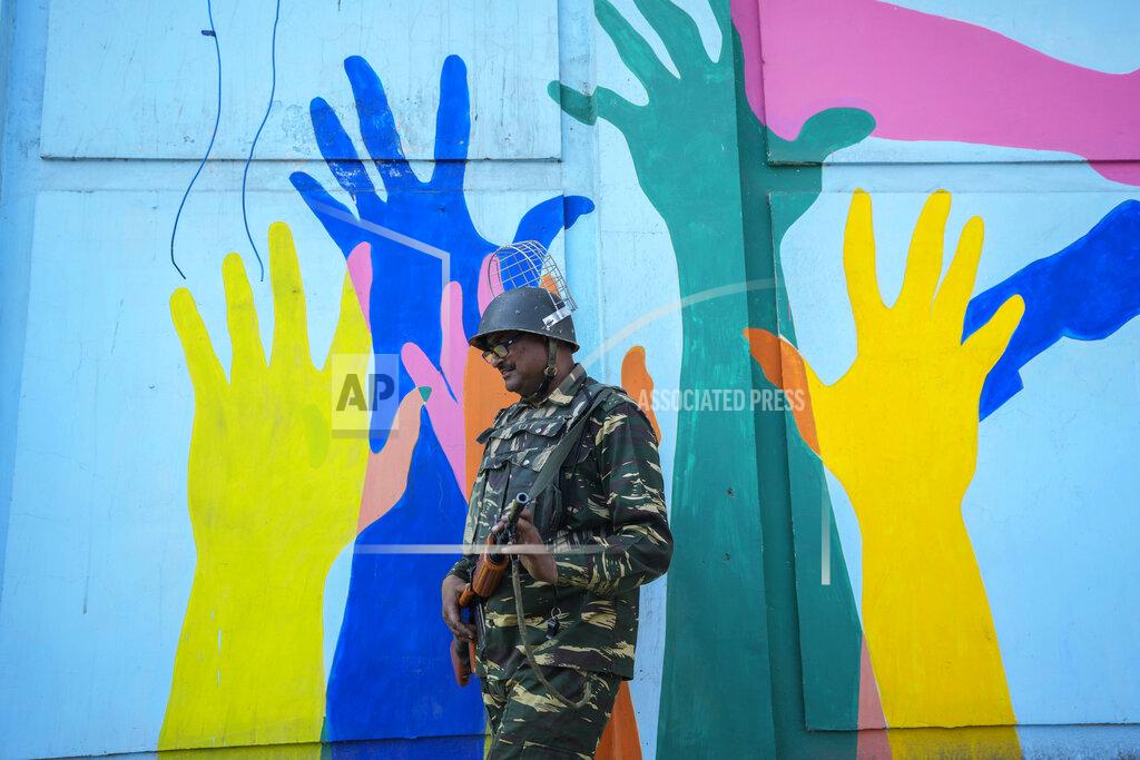 Mukhtar Khan An Indian paramilitary soldier on patrol walks past a mural in Srinagar, Indian controlled Kashmir, Thursday, May 26, 2022. Police in disputed Kashmir arrested at least 10 youths during overnight raids following an anti-India protest that erupted as an Indian court sentenced a prominent Kashmiri pro-independence leader to life in prison, officials said Thursday. (AP Photo/Mukhtar Khan)