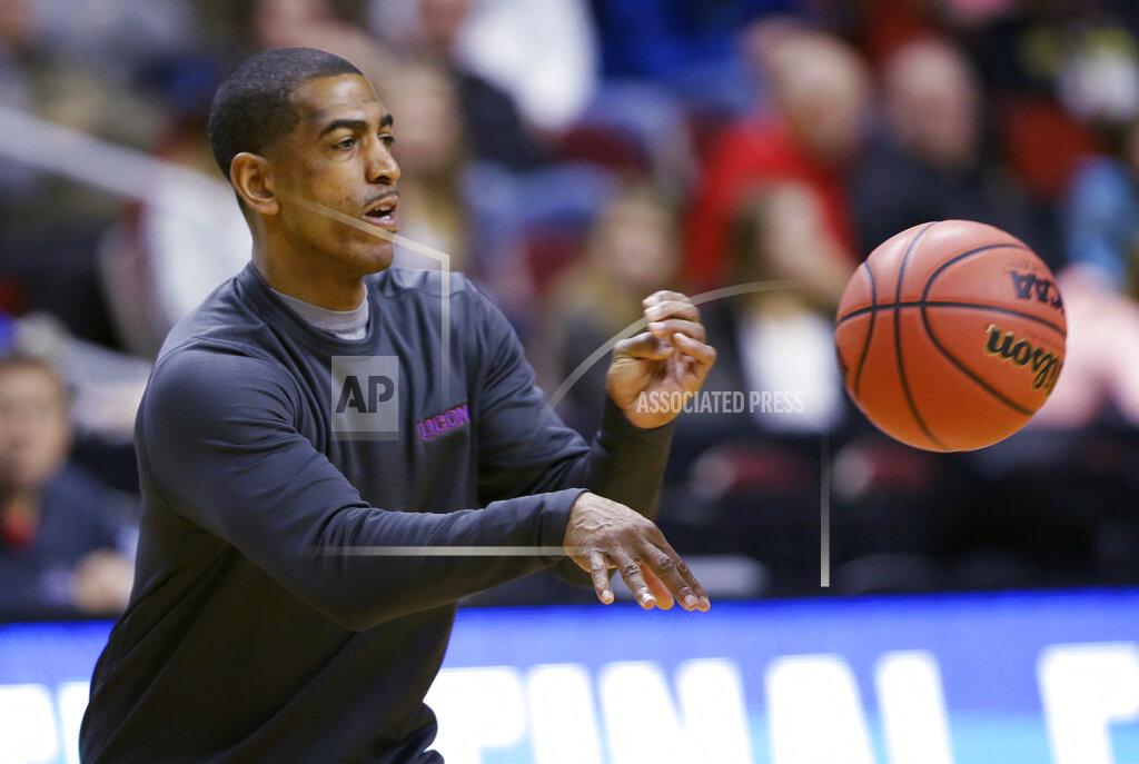 FILE - In this March 16, 2016, file photo, Connecticut coach Kevin Ollie passes the ball during practice for the team's first-round game in the NCAA men's college basketball tournament in Des Moines, Iowa. Former UConn basketball coach Ollie has brought his $10 million dispute with the school over his firing to both state and federal court. Lawyers for Ollie and the university were to give oral arguments Friday, Jan. 25, in U.S. District Court in Bridgeport on a motion that would allow Ollie to move forward with a racial discrimination complaint against the school without jeopardizing his right to an arbitration hearing with UConn over his firing last year. (AP Photo/Charlie Neibergall, File)