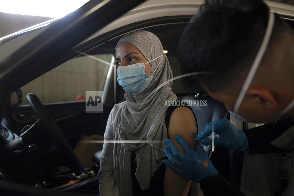 FILE - In this March 5, 2021, file photo, Dian Rana receives Pfizer's COVID-19 vaccine at a vaccination site in Long Beach, Calif. U.S. deaths from COVID-19 are falling again as the nation recovers from the devastating winter surge. Most forecasts predict coronavirus deaths will fall further in coming weeks, as more people are vaccinated. (AP Photo/Jae C. Hong, File)