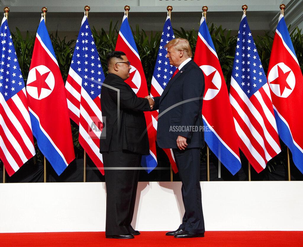 Evan Vucci FILE - In this June 12, 2018, file photo, North Korean leader Kim Jong Un, left, and U.S. President Donald Trump shake hands prior to their meeting on Sentosa Island in Singapore. As Americans celebrate or fume over the new president-elect, many in Asia are waking up to the reality of a Joe Biden administration with decidedly mixed feelings. Relief and hopes of economic and environmental revival jostle with needling anxiety and fears of inattention. Biden has endorsed a slower approach built from working-level meetings and said he would be willing to tighten sanctions on the North until it takes concrete denuclearization steps. (AP Photo/Evan Vucci, File)