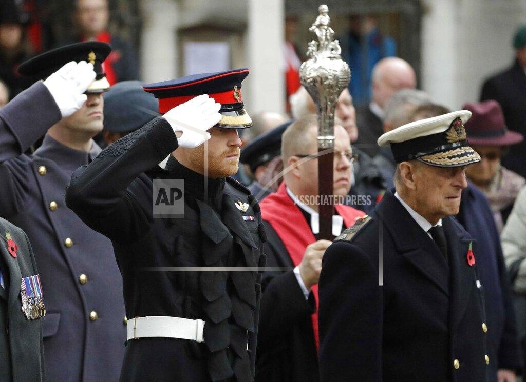 Matt Dunham FILE - In this file photo dated Thursday, Nov. 10, 2016, Britain's Prince Harry salutes as he and Prince Philip attend the official opening of the annual Field of Remembrance at Westminster Abbey in London. The Field of Remembrance pays tribute to all the people who have served in the British armed forces since World War I. Prince Philip who died Friday April 9, 2021, aged 99, lived through a tumultuous century of war and upheavals, but he helped forge a period of stability for the British monarchy under his wife, Queen Elizabeth II. The decades brought family troubles, including the self-exile of grandson Prince Harry and his wife Meghan amid allegations of racism.(AP Photo/Matt Dunham, FILE)