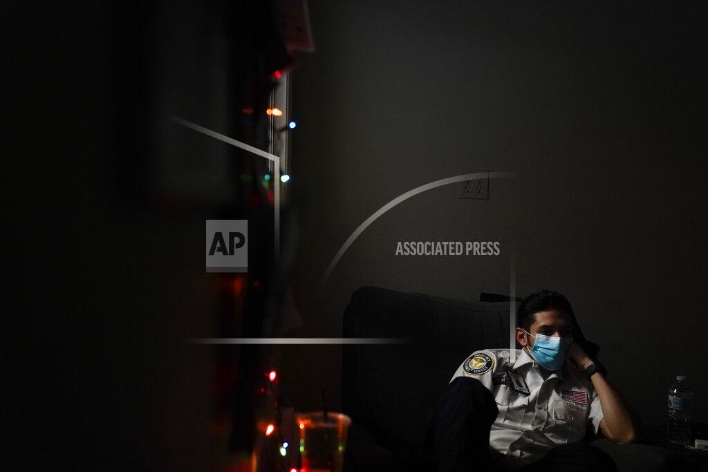 Jae C. Hong Emergency medical technician Joshua Hammond, 25, of Emergency Ambulance Service, watches TV while on standby for a dispatch call in Placentia, Calif., Friday, Jan. 8, 2021. (AP Photo/Jae C. Hong)