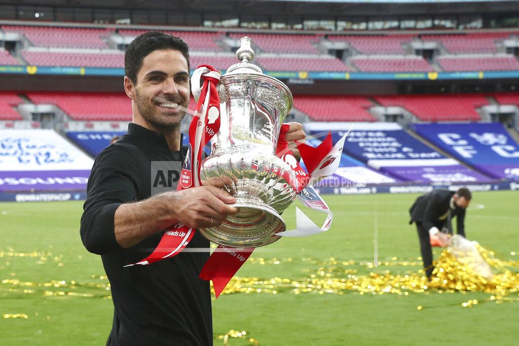 Catherine Ivill Arsenal's head coach Mikel Arteta walks with the trophy after the FA Cup final soccer match between Arsenal and Chelsea at Wembley stadium in London, England, Saturday, Aug.1, 2020. (Catherine Ivill/Pool via AP)