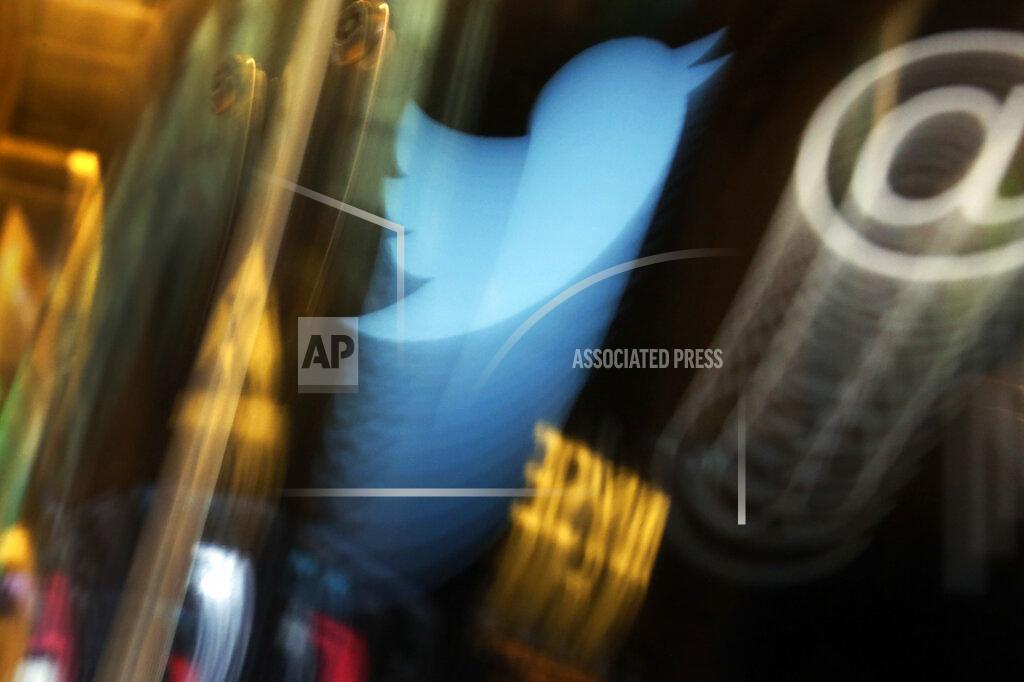 FILE - In this Wednesday Nov. 6, 2013, file photo, the Twitter logo appears on an updated phone post on the floor of the New York Stock Exchange. Twitter says the hackers responsible for a recent high-profile breach used the phone to fool the social media company's employees into giving them access. The company revealed a few more details late Thursday, July 30, 2020 about the hack earlier this month, which it said targeted “a small number of employees through a phone spear phishing attack.” (AP Photo/Richard Drew, File)