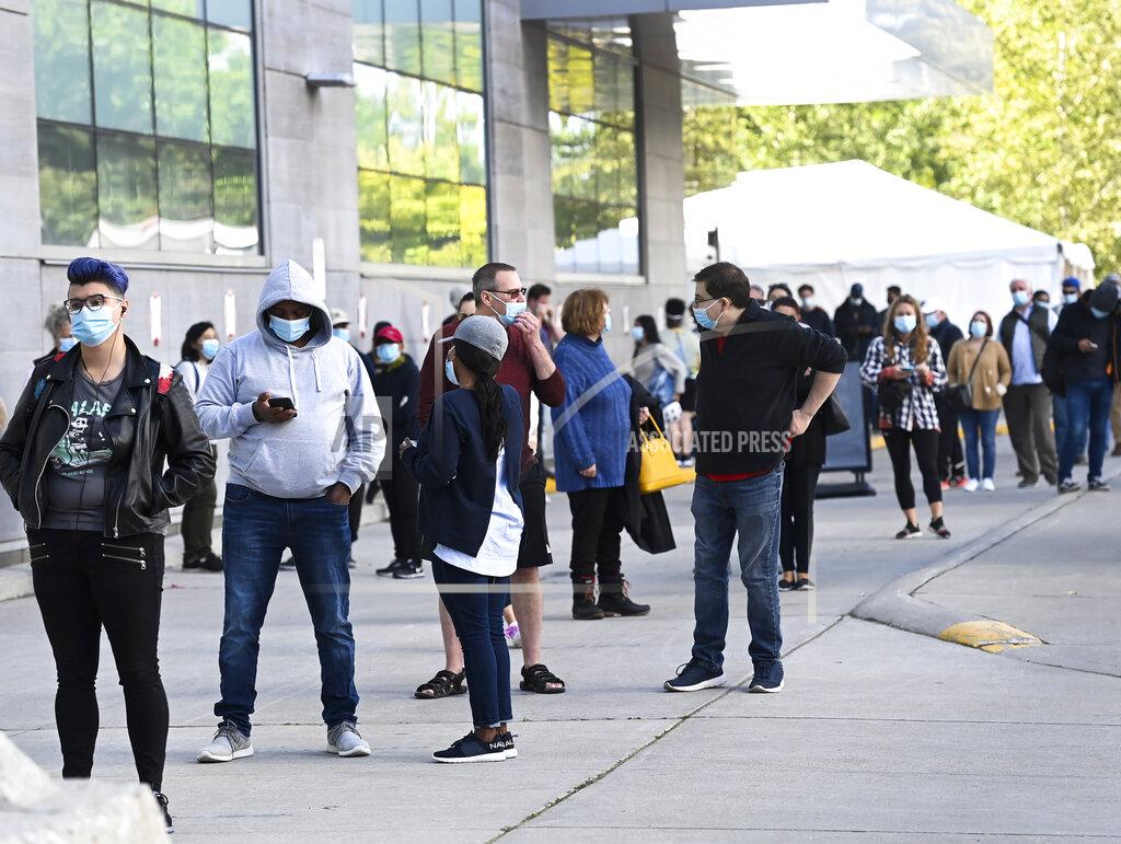 Nathan Denette Hundreds of people wait in line for hours at a COVID-19 assessment centre at Women's College Hospital during the coronavirus pandemic in Toronto, Wednesday, Sept. 23, 2020. (Nathan Denette/The Canadian Press via AP)