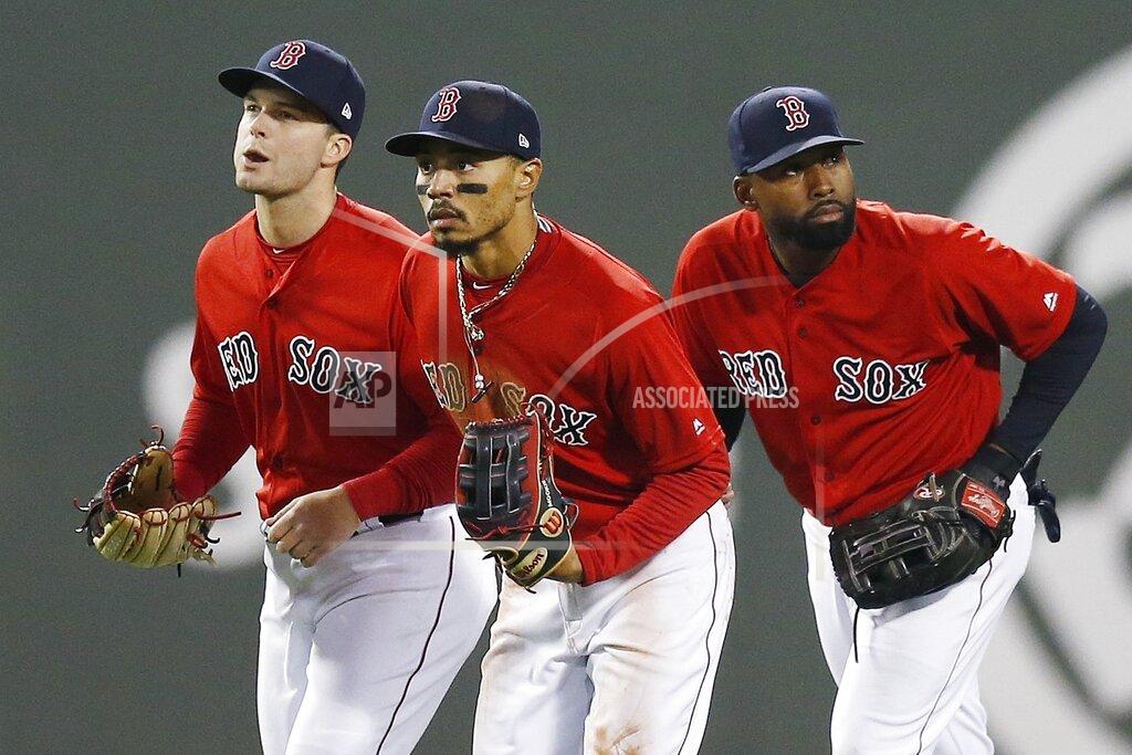 FILE - In this Friday, April, 12, 2019 file photo, Boston Red Sox's Andrew Benintendi, left, Mookie Betts, center, and Jackie Bradley Jr. run in after defeating the Baltimore Orioles during a baseball game in Boston. When the Boston Red Sox traded Mookie Betts to the Los Angeles Dodgers on the eve of spring training, they broke up the
