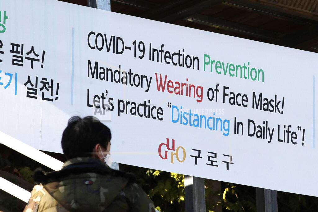 Lee Jin-Man A man wearing a face mask walks by a banner showing precautions against the coronavirus in Seoul, South Korea, Monday, Nov. 23, 2020. (AP Photo/Lee Jin-man)