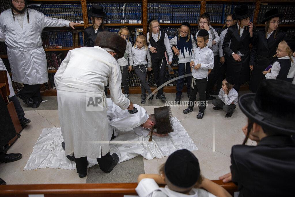 Oded Balilty An ultra-Orthodox Jewish man whips a member of his Hasidic dynasty with a leather strap as a symbolic punishment for his sins last year's, during the traditional Malkot (whipping in Hebrew) ceremony, ahead of Yom Kippur that begins at sunset, in the city of Beit Shemesh, near Jerusalem, Wednesday, Sept. 15, 2021. Yom Kippur is Judaism's day of atonement, when devout Jews ask God to forgive them for their transgressions and refrain from eating and drinking, attending intense prayer services in synagogues. (AP Photo/Oded Balilty)