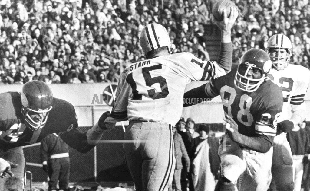 Anonymous FILE - In this Nov. 23, 1970, file photo, Green Bay Packers quarterback Bart Starr (15) looks for a receiver as Minnesota Vikings' Alan Page (88) charges him and Carl Eller (81), left, grabs his arm during second half of an NFL football game in Minneapolis, Minn. Page, a future Minnesota Supreme Court justice was a member of the Purple People Eaters. (AP Photo/File)