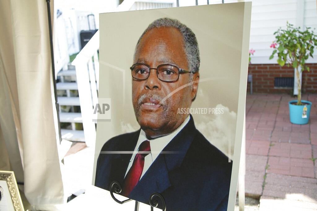 Allen G. Breed A photo of the late William Penn Troy Sr. stands on an easel during a ceremony in Mullins, S.C., on Saturday, May 22, 2021, to dedicate a local road in his honor. The funeral director and local leader died of COVID-19 in August 2020, one of dozens of Black morticians to succumb during the pandemic. (AP Photo/Allen G. Breed)