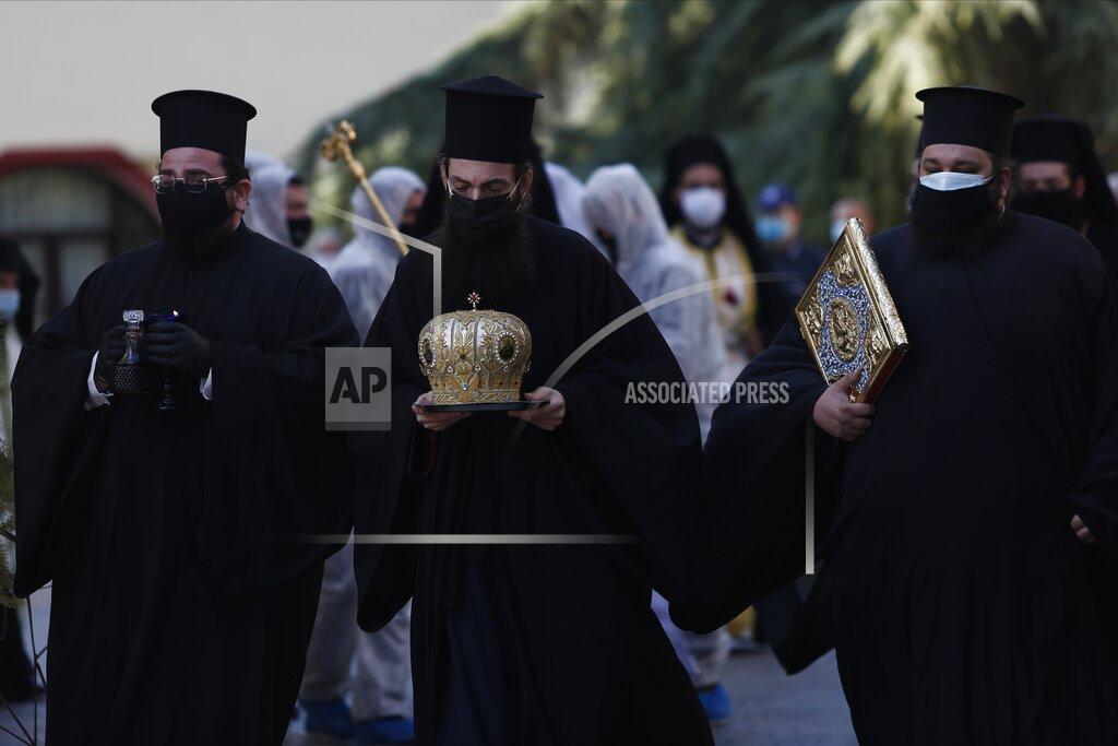 Giannis Papanikos Priests wearing face masks to protect against the spread of the coronavirus, attend the funeral of senior clergyman Ioannis of Lagadas after he died of COVID-19, in Greece's Orthodox Church, in the northern city of Thessaloniki, Greece, Monday, Nov. 16, 2020. Metropolitan Bishop Ioannis of Lagadas, 62, was an outspoken advocate of maintaining communion ceremonies _ at which worshipers are given bread as well as wine with a shared spoon _ during the pandemic, arguing that there was no risk of transmission. (AP Photo/Giannis Papanikos)