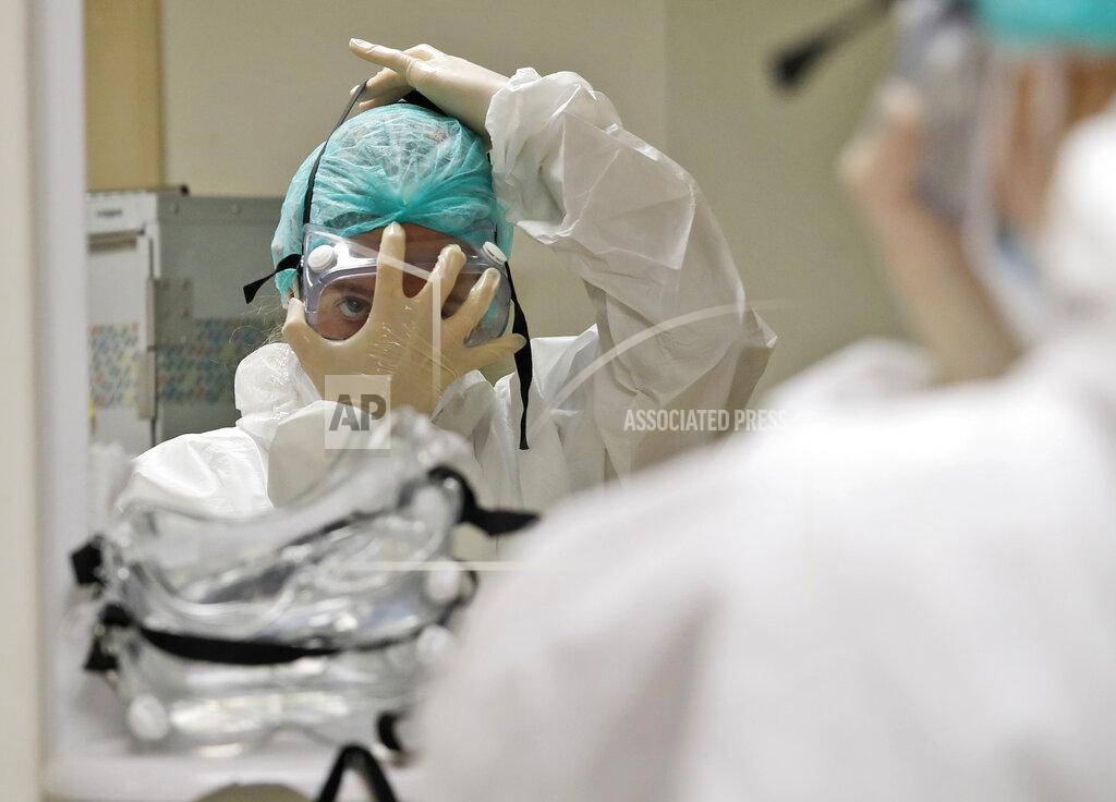 Alessandra Tarantino Nurse Ginevra Fattori adjusts her protective equipment before entering the sub-intensive care unit of the San Filippo Neri hospital in Rome, Thursday, Oct. 29, 2020. (AP Photo/Alessandra Tarantino)