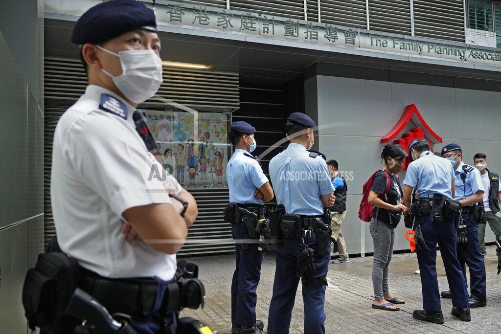 Vincent Yu Chen Baoying, right with red backpack, one of the four protesters is searched by police officers during a protest against an election committee in Hong Kong Sunday, Sept. 19, 2021. Hong Kong's polls for an election committee that will vote for the city's leader kicked off Sunday amid heavy police presence, with chief executive Carrie Lam saying that it is "very meaningful" as it is the first election to take place following electoral reforms. (AP Photo/Vincent Yu)