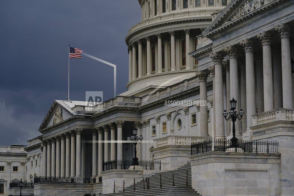 FILE - In this Aug. 3, 2020, file photo dark clouds and heavy rain sweep over the U.S. Capitol in Washington. The federal budget deficit is projected to hit a record $3.3 trillion as huge government expenditures to fight the coronavirus and to prop up the economy have added more than $2 trillion to the federal ledger, the Congressional Budget Office said Wednesday, Sept. 2. (AP Photo/J. Scott Applewhite, File)