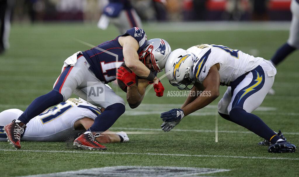 Charles Krupa New England Patriots wide receiver Julian Edelman (11) and Los Angeles Chargers linebacker Uchenna Nwosu (42) collide on their helmet crowns during the second half of an NFL divisional playoff football game, Sunday, Jan. 13, 2019, in Foxborough, Mass. (AP Photo/Charles Krupa)