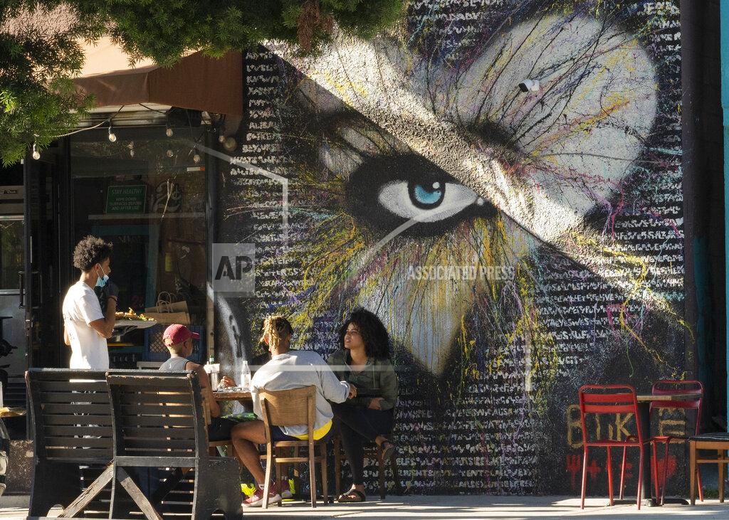Damian Dovarganes People eat outdoors outdoors at a soul food restaurant in Los Angeles on Saturday, Jun. 5, 2021. Most of California's coronavirus restrictions on businesses and public gatherings will end June 15. (AP Photo/Damian Dovarganes)