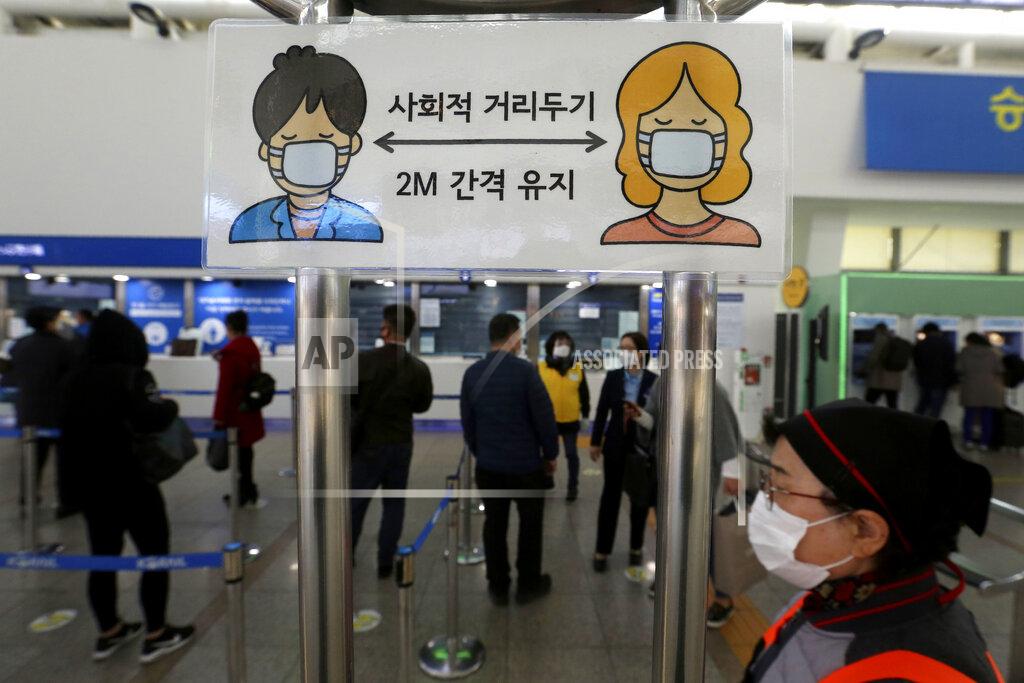 Ahn Young-Joon A social distancing sign is seen as people wait to buy tickets at the Seoul Railway Station in Seoul, South Korea, Friday, Nov. 13, 2020. South Korea has reported its biggest daily jump in COVID-19 cases in 70 days as the government began fining people who fail to wear masks in public. The Korean letters read "Social distance and keep 2 meter away."(AP Photo/Ahn Young-joon)