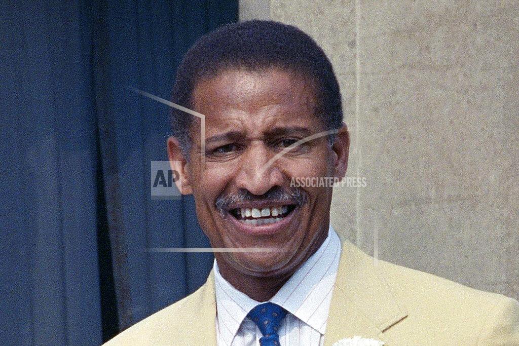 Uncredited FILE - This 1990 file photo shows Former football player Junious "Buck" Buchanan during induction ceremonies at the Pro Football Hall of Fame in Caston, Ohio. Two years before Clark Hunt was born, the Kansas City Chiefs made history by taking Grambling State defensive tackle Buck Buchanan in the American Football League draft, making him the first black player from any college — much less a historically black one — to be the first player selected first overall. It was a testament to the progressive nature of Hunt's father, Chiefs founder Lamar Hunt. (AP Photo/File)