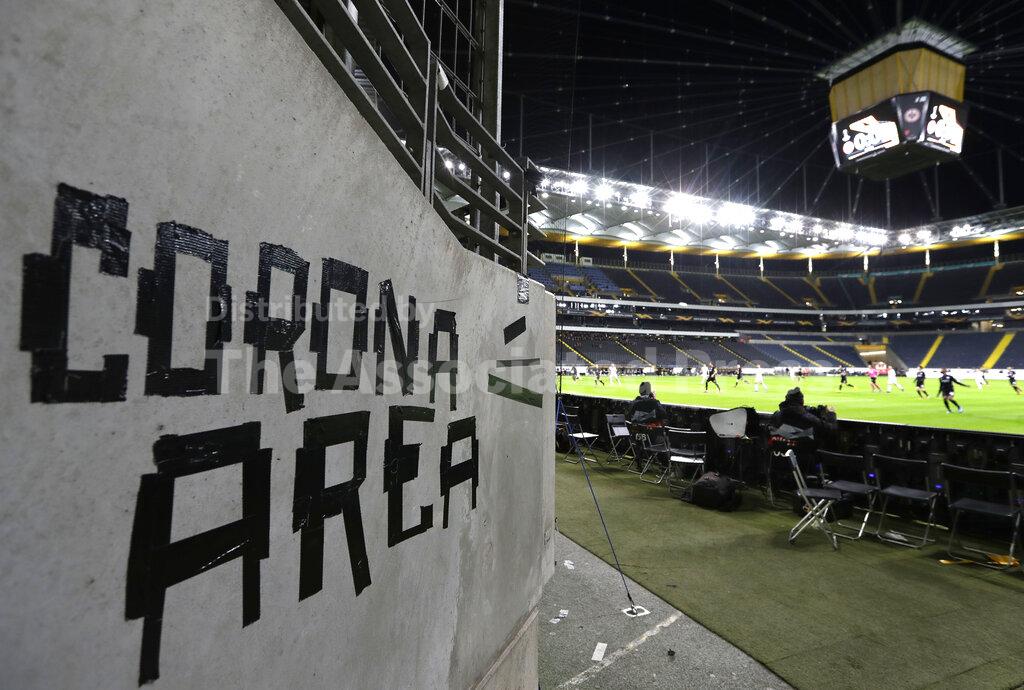Eintracht fans have taped letters at a wall of the stadium during a Europa League round of 16, 1st leg soccer match between Eintracht Frankfurt and FC Basel in Frankfurt, Germany, Thursday, March 12, 2020. The match was played in an empty stadium because of the coronavirus outbreak. For most people, the new coronavirus causes only mild or moderate symptoms, such as fever and cough. For some, especially older adults and people with existing health problems, it can cause more severe illness, including pneumonia. (AP Photo/Michael Probst)