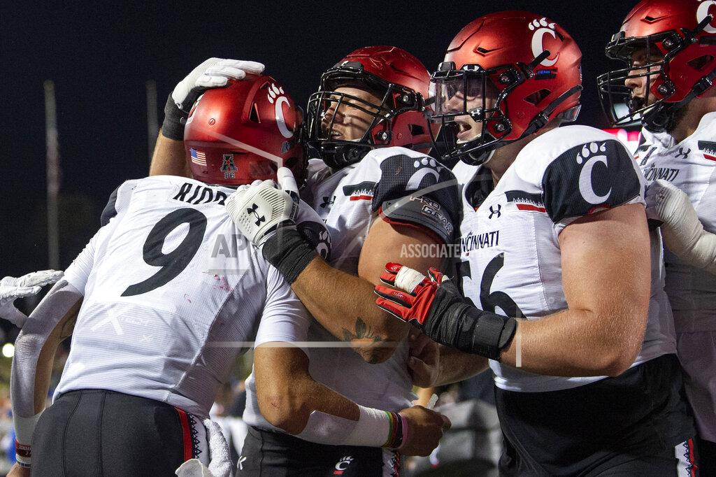 Jeffrey Mcwhorter Cincinnati quarterback Desmond Ridder (9) is congratulated by offensive linemen Vincent McConnell, center, and Jake Renfro (56) after a touchdown run against SMU during the second half of an NCAA college football game Saturday, Oct. 24, 2020, in Dallas. (AP Photo/Jeffrey McWhorter)