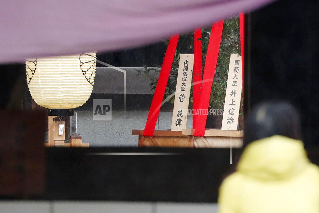 Masanori Kumagai A visitor stands near religious ornaments at the Yasukuni Shrine in Tokyo Saturday, Oct. 17, 2020. While Japan’s new Prime Minister Yoshihide Suga’s own personal ideology is unknown, he followed his former boss Shinzo Abe's example in making ritual donations of religious ornaments Saturday to the Yasukuni Shrine to pay respect to the war dead. A sign, left, reads "Prime Minister Yoshihide Suga." (Masanori Kumagai/Kyodo News via AP)
