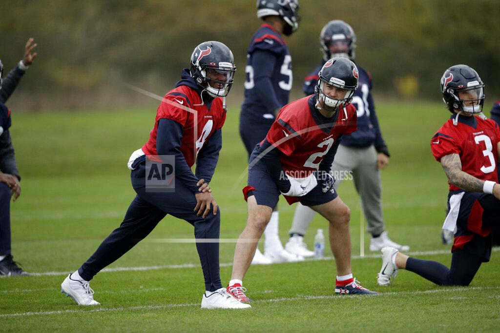 Matt Dunham Houston Texans' quarterback Deshaun Watson, 4, stretches next to quarterback AJ McCarron, 2, and quarterback Alex McGough, 3, during an NFL practice session at the London Irish rugby team training ground in the Sunbury-on-Thames suburb of south west London, Friday, Nov. 1, 2019. The Houston Texans are preparing for an NFL regular season game against the Jacksonville Jaguars in London on Sunday. (AP Photo/Matt Dunham)
