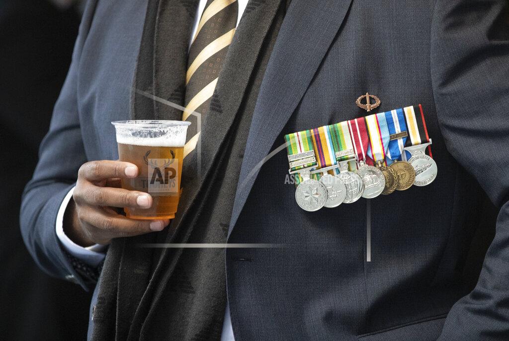 Mark Baker A veteran enjoys a beer ahead of the Anzac Day parade in Sydney, Australia, Sunday, April 25, 2021. Australians and New Zealanders paid tribute to their war dead Sunday as both nations prepared to withdraw from their longest war in Afghanistan. (AP Photo/Mark Baker)