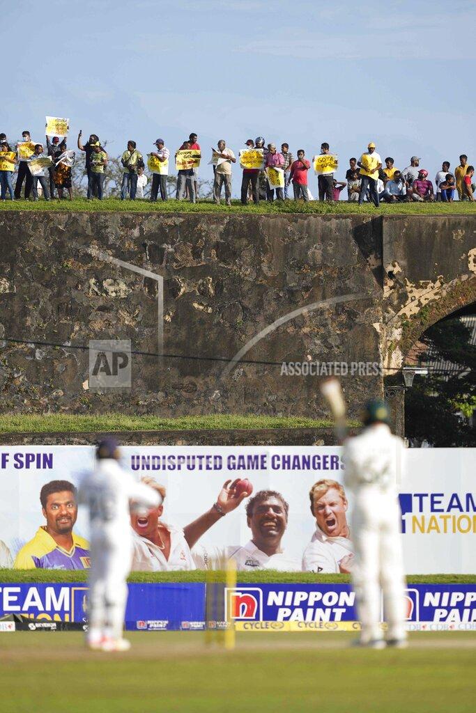 Eranga Jayawardena Anti government demonstrators protest from the 17th century built Dutch Fort during the day two of the first test cricket match between Australia and Sri Lanka in Galle, Sri Lanka, Thursday, June 30, 2022. The island nation is coping with an unprecedented economic crisis and severe shortages of essential supplies. (AP Photo/Eranga Jayawardena)