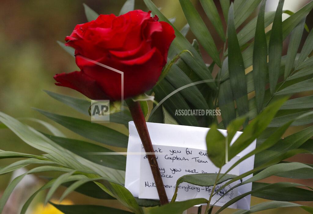 Alastair Grant A rose among floral tributes laid in memory of Captain Tom Moore on the village green in Marston Moretaine, England, Wednesday, Feb. 3, 2021. Captain Tom Moore, the 100-year-old World War II veteran who captivated the British public in the early days of the coronavirus pandemic with his fundraising efforts for health care workers, died Tuesday. (AP Photo/Alastair Grant)