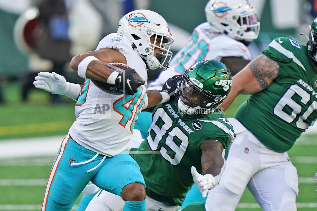Corey Sipkin Miami Dolphins' Nik Needham, left, runs the ball after intercepting a throw by New York Jets' quarterback Sam Darnold during the second half of an NFL football game, Sunday, Nov. 29, 2020, in East Rutherford, N.J. (AP Photo/Corey Sipkin)