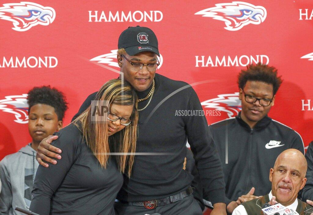 Tracy Glantz In this Dec. 18, 2019 photo, Hammond's Jordan Burch hugs his mom, Henri Burch, after announcing that he would attend South Carolina to play football during a signing day event in Columbia. S.C. The-6-foot-5, 275-pound Burch is a potential immediate-impact player out for the Gamecocks. When the early signing period opened in December he announced he would stay close to home. But he didn't actually sign, leaving open the possibility LSU could be his final destination. (Tracy Glanz/The State via AP)