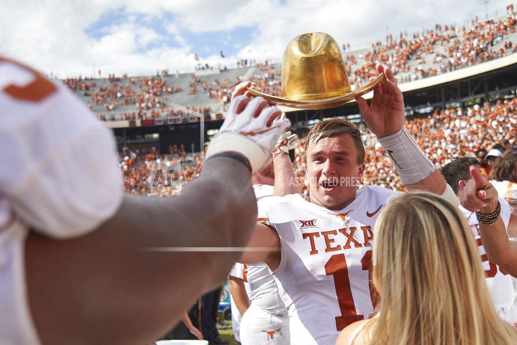 Cooper Neill Texas quarterback Sam Ehlinger (11) holds the Golden Hat as he celebrates with teammates after defeating Oklahoma 48-45 in an NCAA college football game at the Cotton Bowl, Saturday, Oct. 6, 2018, in Dallas. (AP Photo/Cooper Neill)