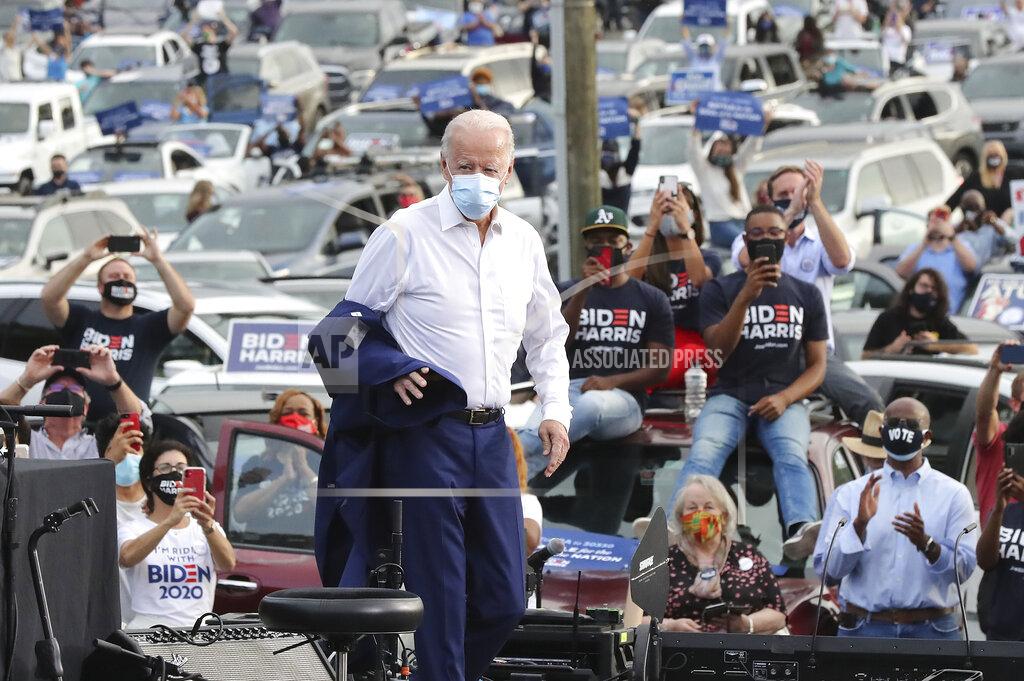 Curtis Compton 102720 Atlanta: Democratic Presidential candidate Joe Biden takes off his jacket arriving at his drive in rally event during his visit to Georgia at the amphitheatre at Lakewood on Tuesday, Oct 27, 2020 in Atlanta. (Curtis Compton/Atlanta Journal-Constitution via AP)