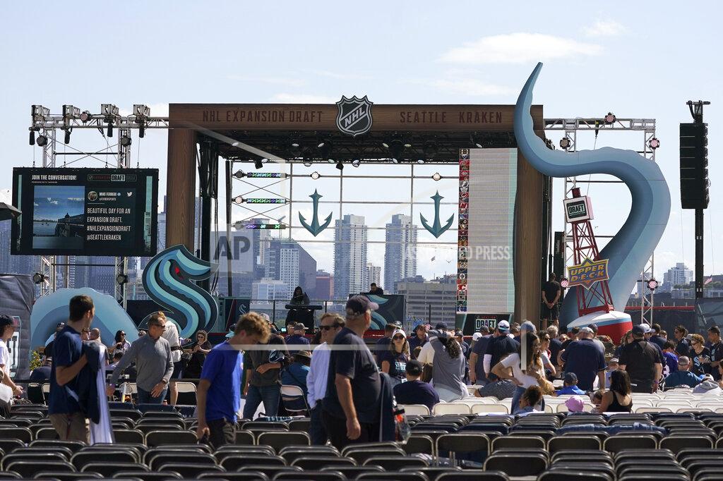 Ted S. Warren Fans take their seats Wednesday, July 21, 2021, near the stage in a Seattle park before the Seattle Kraken NHL hockey team's expansion draft event. (AP Photo/Ted S. Warren)