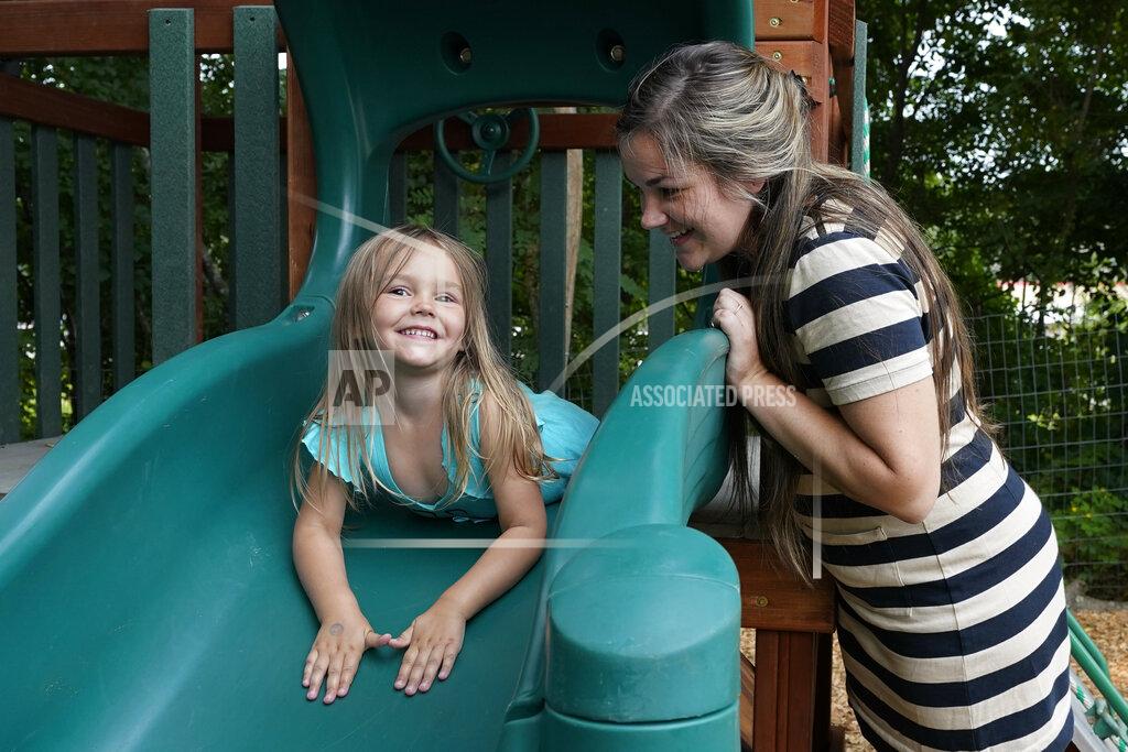Elise Amendola In this July 26, 2021 photo, Brianne Walker plays with her 3-year-old daughter, Jeannette, at A Place To Grow daycare in Brentwood, N.H. Walker and her family have qualified for the expanded child tax credit, part of President Joe Biden's $1.9 trillion coronavirus relief package. "The additional money does help alleviate the pressure," said Walker, 29, who took custody of her two siblings last year after her mother overdosed. The $800 credit will help make up for losses she incurred after quitting a kitchen design job to care for her three children, as well as her two younger brothers. (AP Photo/Elise Amendola)