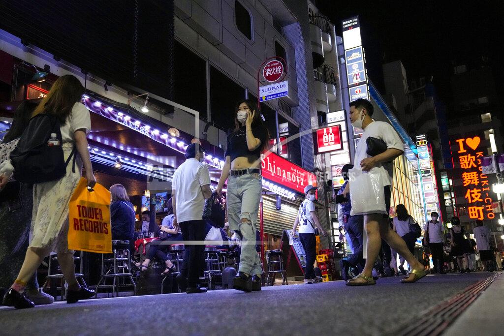 Kiichiro Sato People walk around and gather at a bar after government imposed 8 p.m. closing time for restaurants and bars under Tokyo's fourth state of emergency Saturday, July 17, 2021, in Tokyo. The latest state of emergency has asked restaurants and bars to close by 8 p.m., if not entirely. This has pushed people to drink outside, although many bars remain open and bustling with customers who are defying the rules and expressing frustration and indifference. (AP Photo/Kiichiro Sato)