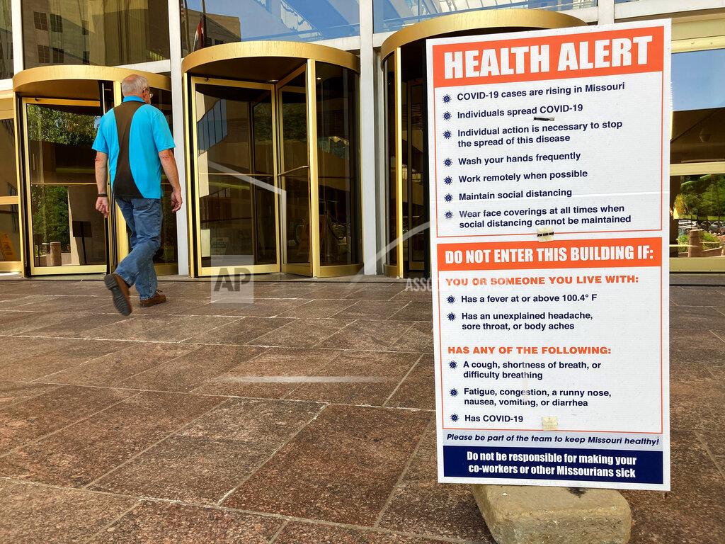David A. Lieb A sign warning of COVID-19 dangers remains in place Tuesday, June 15, 2021, outside the entryway of a state office building in Jefferson City, Mo. Missouri Gov. Mike Parson signed a law Tuesday limiting the duration of local public health restrictions such as capacity limits at workplaces and public gathering spots. (AP Photo/David A. Lieb)