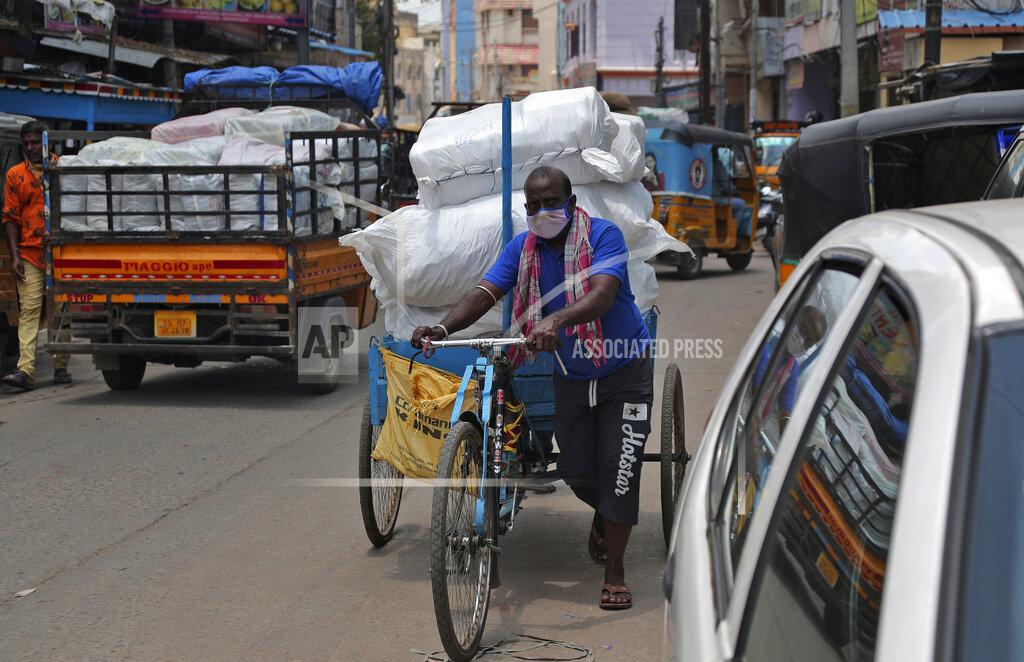 Mahesh Kumar A An Indian cycle rickshaw puller wearing face mask transports a load in Hyderabad, India, Thursday, June 25, 2020. India is the fourth hardest-hit country by the pandemic in the world after the U.S., Russia and Brazil. (AP Photo/Mahesh Kumar A.)